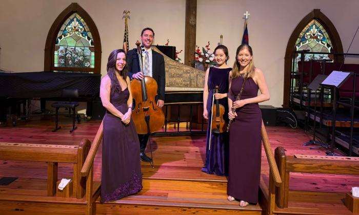 The four members of the Astralis quartet, standing in front of a harpsichord