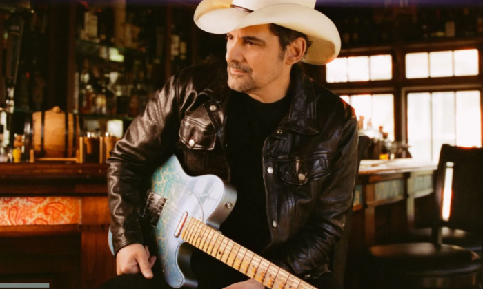Brad Paisley poses with a white cowboy hat and matching guitar.
