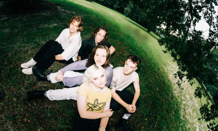 Bandmates from Flipturn pose on grass.