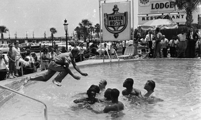 A police officer jumps into a hotel pool in the 1960s to remove black youth