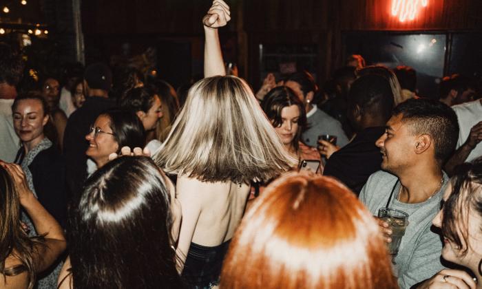 A handful of people drift together, swaying to the music on the dance floor.
