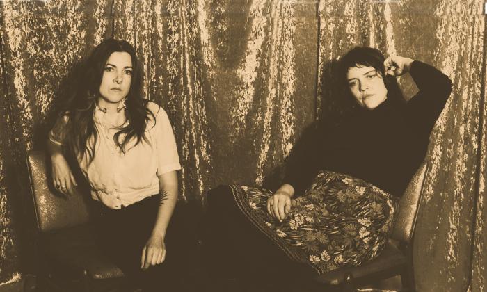The duo Mama's Broke depicted in front of a shiny curtain in a tintype style