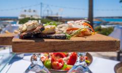 Greek food is placed on top of a cutting board. 