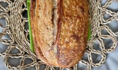 A slide of bread rests on a table with a knit cover. 