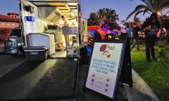 A cook on a food truck prepares food for customers. 