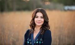 A picture of makeup artist Sarina Durden posing in a field