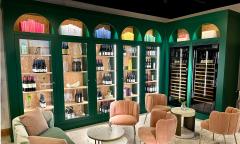 The wine library at Pesca has plush seating and a dark green, glass-fronted wine cellar