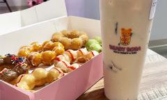 A box of mochi donuts and a milk tea beside it