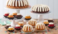 Various cakes with icing on top displayed on the table