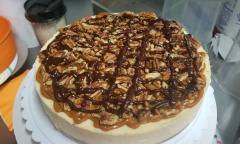 A turtle pecan cheesecake drizzled with chocolate sauce