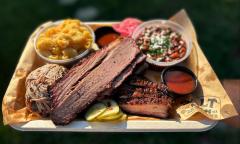 A tray of meats, mac 'n' cheese, and baked beans