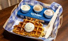 A classic waffle served with a whipped cream flight