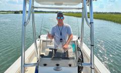 Captain Logan Russom steering his boat