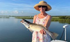 A guest holding up a freshly caught fish