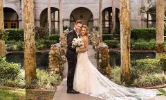 A bridal couple posting for photos on the bridge in the garden of the Lightner Building in St. Augustine.