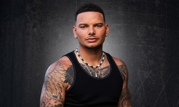 Country singer, Kane Brown, photographed in a black t-shirt against a dark background