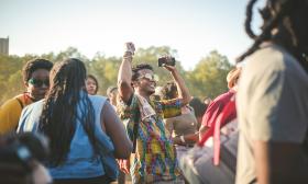 A group of people dance at a festival. 