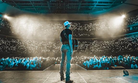 Country musician Parker McCollum on stage in a blue light