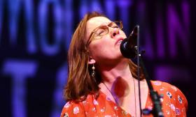 Iris DeMent with microphone, singing