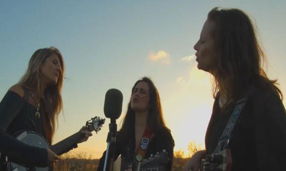 The 3-female band the Krickets playing guitars outdoors and singing harmonies.