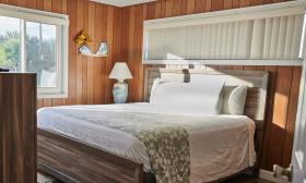 A wood-paneled guest room with a large window, at Oceanview Lodge in Vilano Beach, at St. Augustine