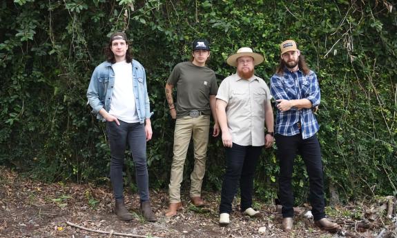 The four members of Cumberland, standing outside near trees