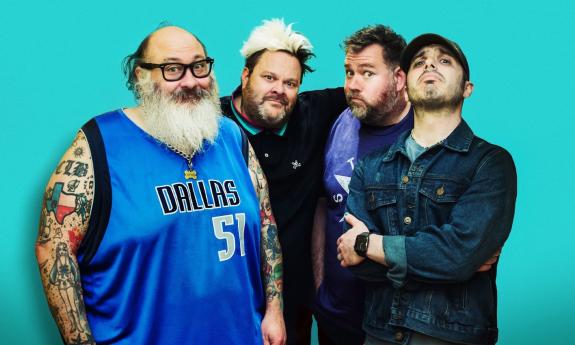 Bandmates from Bowling For Soup and Lit smile and pose in front of a teal background. 