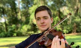 Christian Ward, playing his fiddle outside.