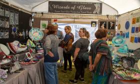 Festival attendees browsing an artisan booth at the Hastings Main Street Fall Festival