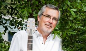 Musician Paul Garfinkel with his guitar, outside