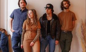 Members of Shadow Grass pose in front of a white wall. 