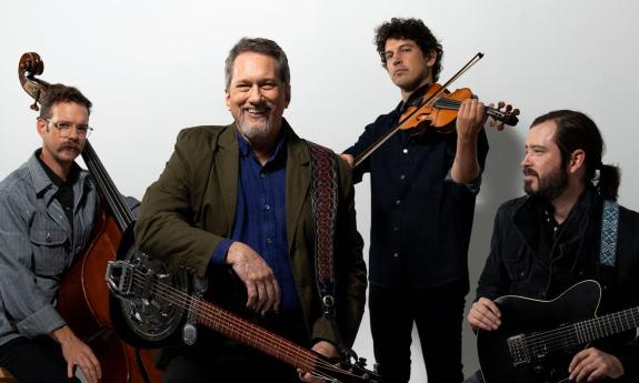 Members of the Jerry Douglas Band smile while holding their musical instruments. 