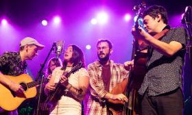 AJ Lee & Blue Summit performing onstage with instruments