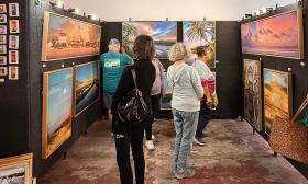 Hastings Main Street Fall Art Festival visitors browsing a curated selection of paintings