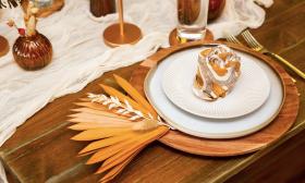 Tablescape with a gold aesthetic and dining ware on a wooden table from The Perch