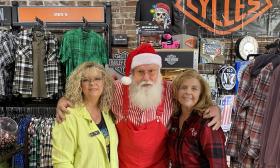 Staff members of Adamec Harley-Davidson standing with Santa