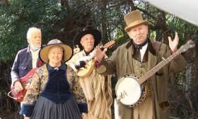 Mary Lee and Frank Sweet, the two members of Backintyme, standing with other musicians