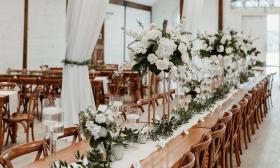 Floral arrangements placed on a long table for a wedding reception