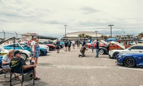 Car owners and visitors and classic cars at a show at the St. Augsutine Airport