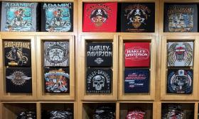 Some of the Harley-Davidson t-shirt designs on display in a wooden case