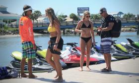 People on the dock getting ready to take jet skis out for the afternoon