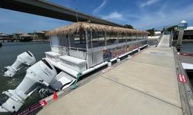 The "Exodos" with twin engines and a palm roof, tied to the dock and waiting for passengers