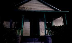 The entry of a small haunted home at night