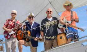 The Landfall Band members on a boat with their instruments