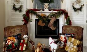 A fireplace and armchairs decorated for the holidays for the annual Holiday Tour of Homes