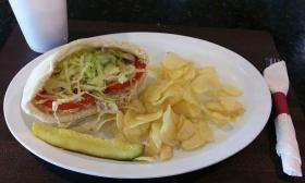 A sandwich, chips, and a pickle served at the eatery