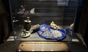 Silver coins in a blue dish on display at the Pirate and Treasure Museum