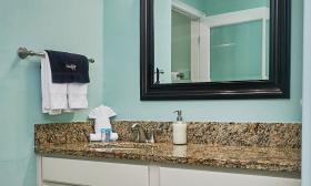 The sink counter in a hotel bathroom has a granite countertop