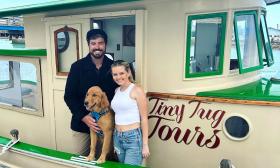 The human and canine crew of the Tiny Tug tour boat includes a young golden retriever