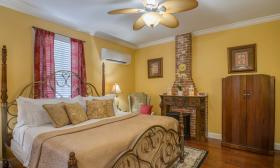 The Aviles guest room has a large bedroom and a private living room, all painted a charming yellow